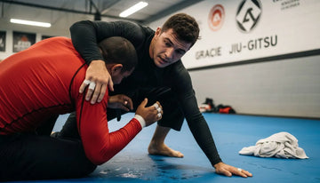 BJJ athletes grappling in gym wearing rashguards