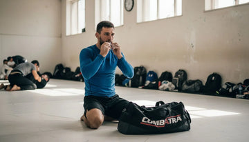 BJJ athlete kneeling mat in gym rashguard