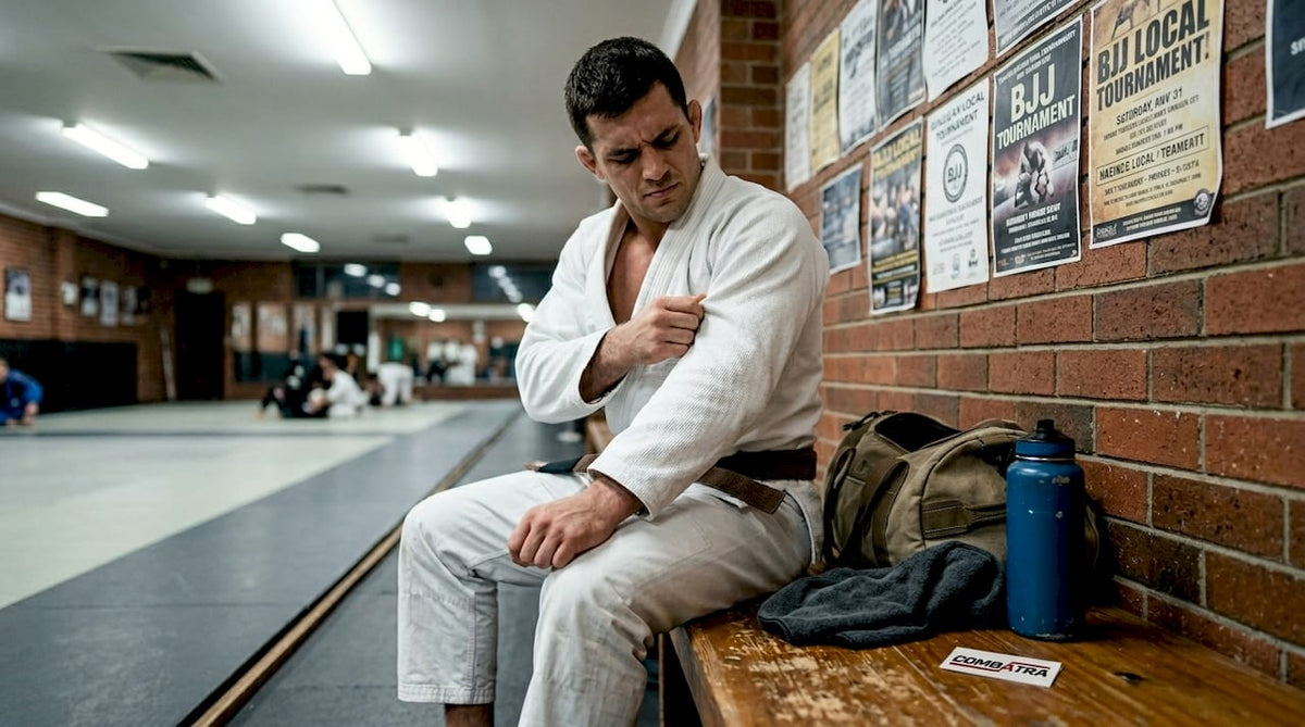 BJJ athlete inspecting white gi fabric on gym bench