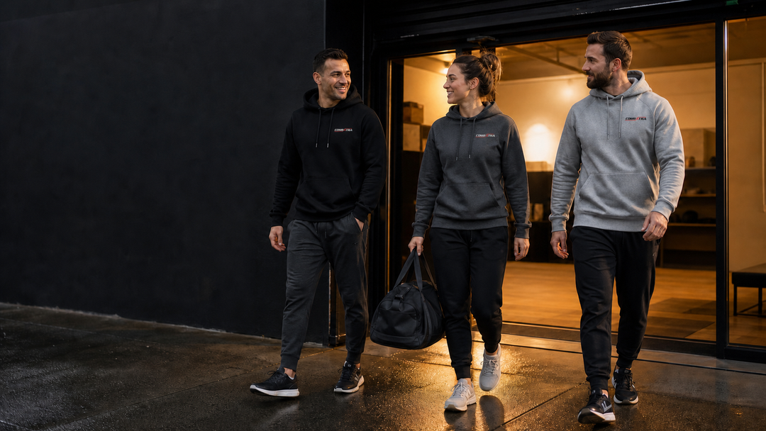 Martial artists leaving an Australian academy in front-branded Combatra hoodies